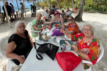 Turistas disfrutando de un almuerzo típico en una isla de San Blas, Guna Yala, Panamá, frente al mar turquesa